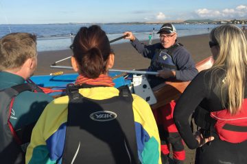 Instructor demonstrating the use of a tiller to a group of students