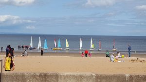 dinghy sailors getting ready to launch from the beach
